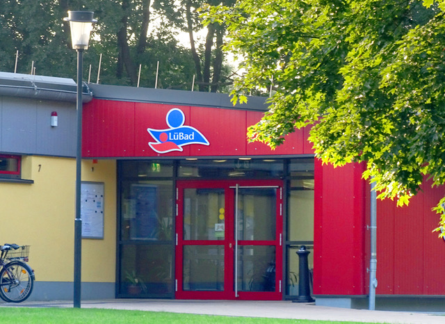 Der rote Eingangsbereich des LüBad mit LüBad-Logo über der Tür