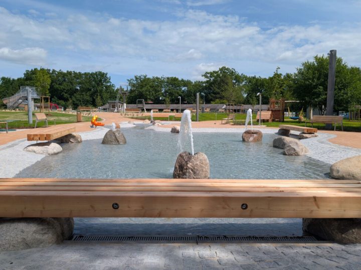 Wasserspielbereich mit sprudelnden Steinen und Holzbänken