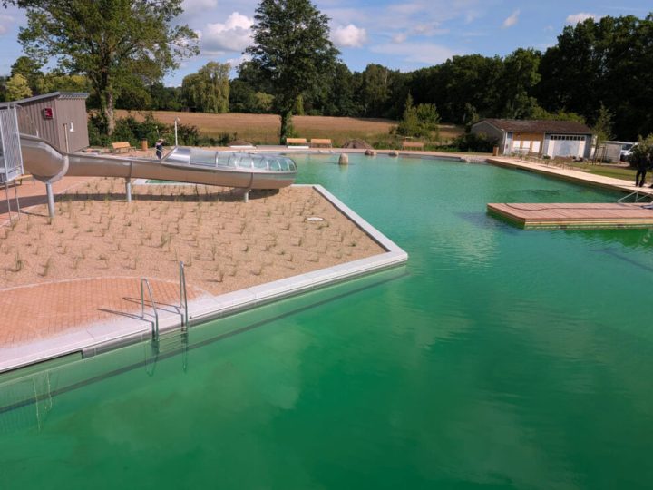 Rutsche und Naturbadbecken in grüner Umgebung